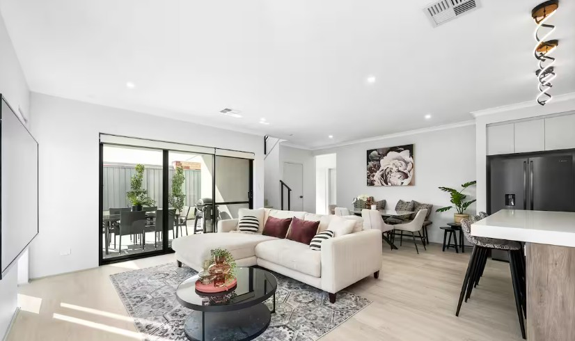 Bright and tidy Airbnb living room with styled cushions and clean rug