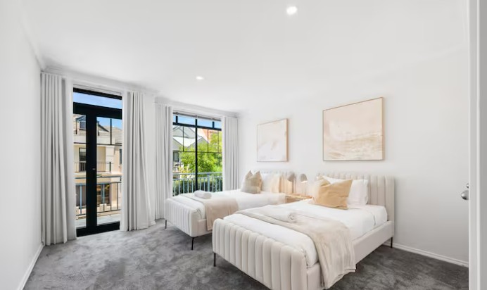 Freshly made bed with crisp white bedding in a bright Airbnb bedroom