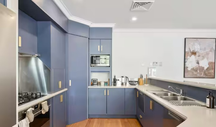 Clean modern kitchen with white countertops and natural light in an Airbnb rental