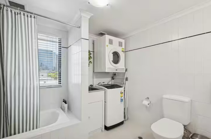 Clean laundry room with organized shelves in a rental property